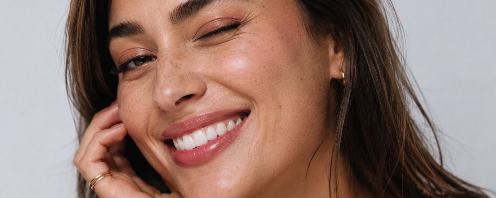 Makeup artist blending SUPERCOVER foundation onto a model's cheek backstage